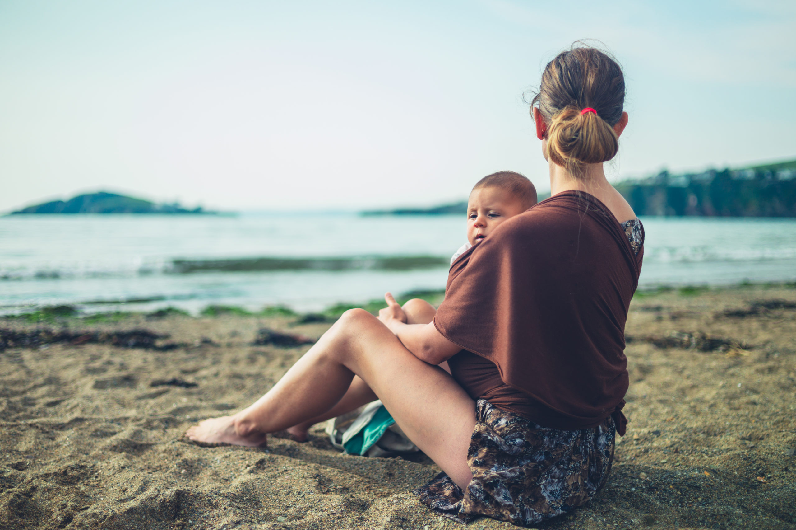 A,Young,Mother,Is,Resting,On,The,Beach,With,Her