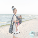 Lady carrying baby while walking on a beach