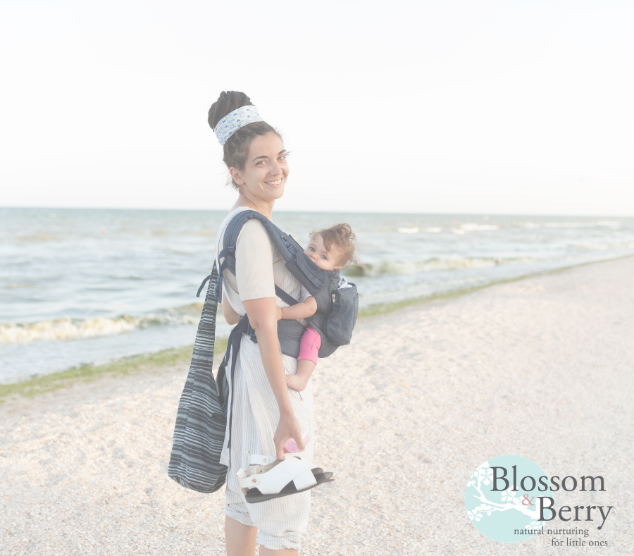 Lady carrying baby while walking on a beach