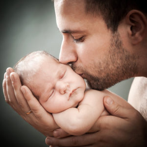 newborn child and father the father holds on hands of the newborn child