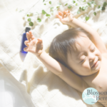 Picture of a baby with arms up in the air and eyes closed