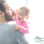 Picture of a man holding a crying baby dressed in pink