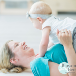 Woman led on the floor holding a baby