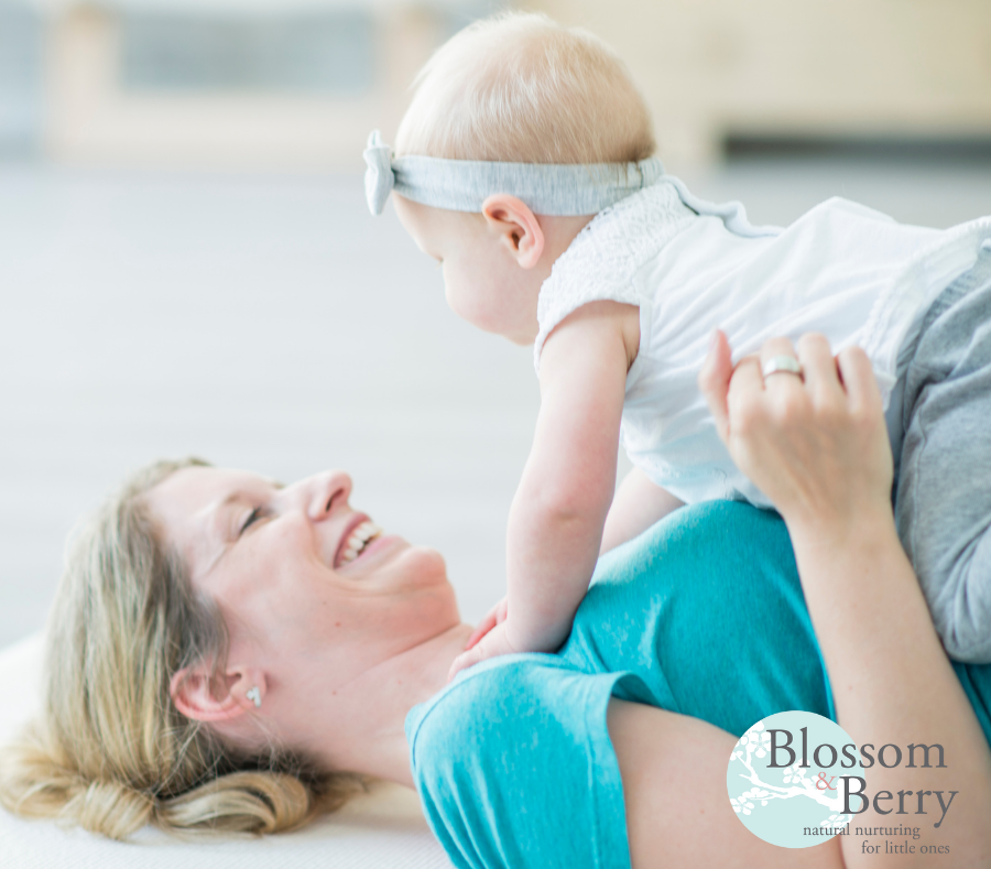 Woman led on the floor holding a baby