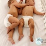 Picture of two sleeping babies in a cot