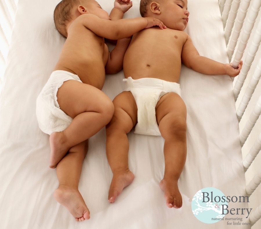 Picture of two sleeping babies in a cot