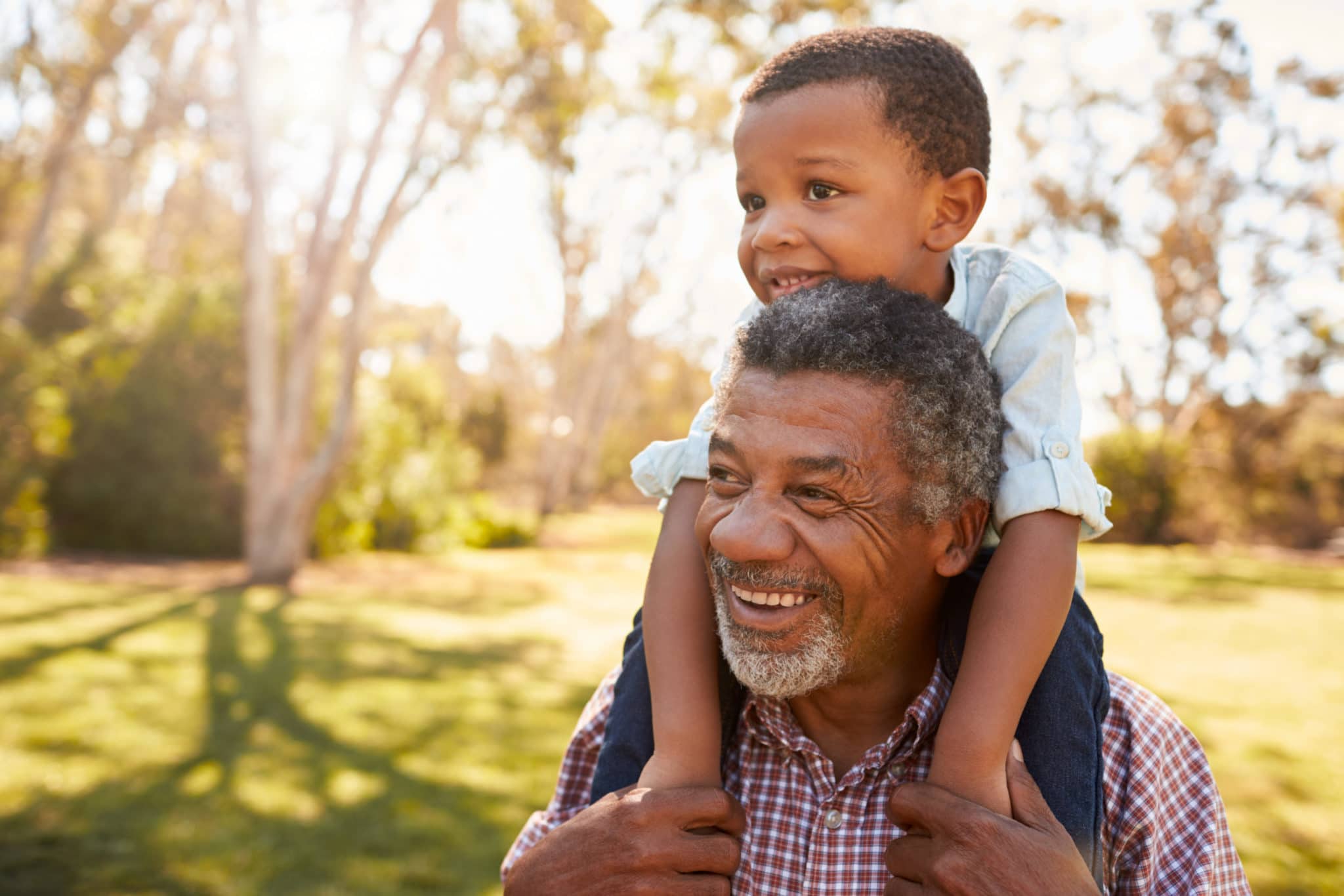 Grandfather,Carries,Grandson,On,Shoulders,During,Walk,In,Park Grandfather,Carries,Grandson,On,Shoulders,During,Walk,In,Park