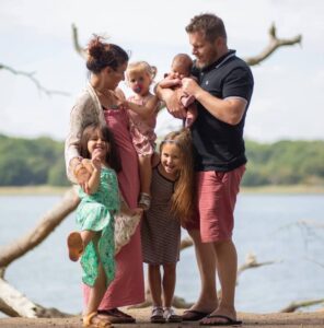 A Village Visionary Case Study - Family photo of Josie with her hsuband and children out in nature