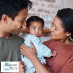 What Qualifications Do You Need to Teach Baby Massage? - picture of a baby being held my a female with a male stood next to her