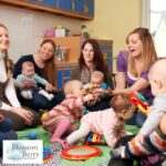 Why Baby Yoga Is Great for New Parents - picture of a group of parents and crawling babies on a playmat