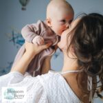 Why Teach Baby Yoga? - picture of a mum holding aloft a baby and snuggling her nose against him