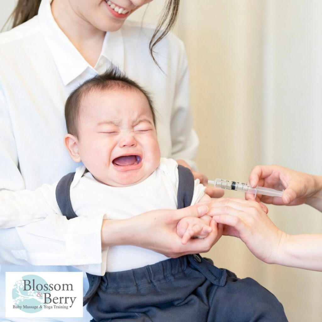 Baby Massage After Vaccination: Safe Tips and Guidelines - picture of a mum holding her baby who is crying as they're having an injection