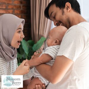 Baby Massage for Motor Development: Benefits, Techniques & Early Movement Support - picture of a mum, dad and baby laughing together