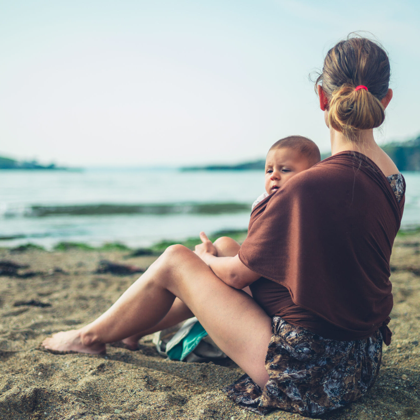 A,Young,Mother,Is,Resting,On,The,Beach,With,Her